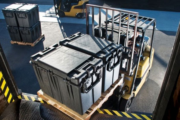 forklift operator loading transit cases into trailer